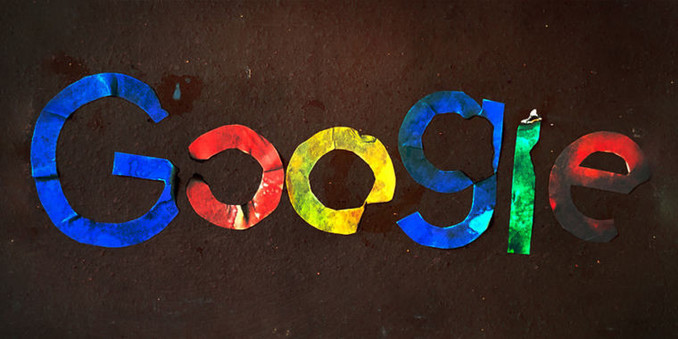 Google logo, seemingly made out of colourful tinfoil pieces laid down in a dirt patch.
