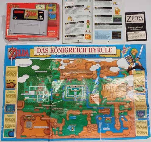A picture featuring a poster of the game "A Link to the Past" showcasing the overworld. Also included are the SNES game cartridge, a game manual, and a guidebook with tips and solutions.