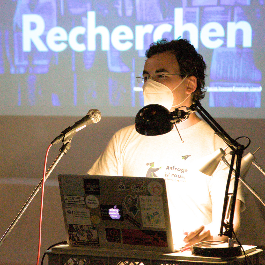 Benjamin am Mikrofon beim Vortrag