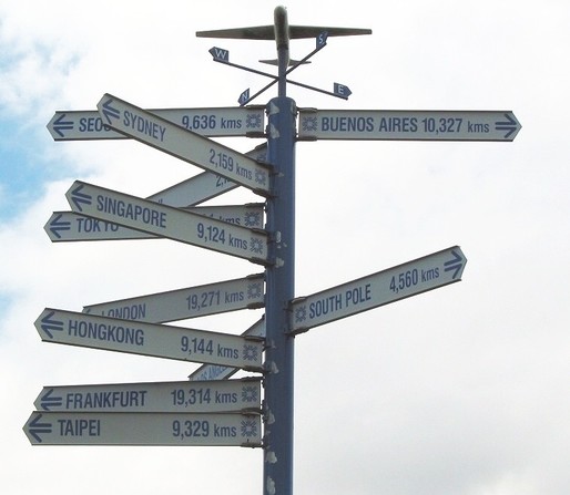 The signpost at Auckland airport to various destinations on the planet. I focus on the examples to Europe: London 19,271 kms, Frankfurt (where I came from) 19,314 kms