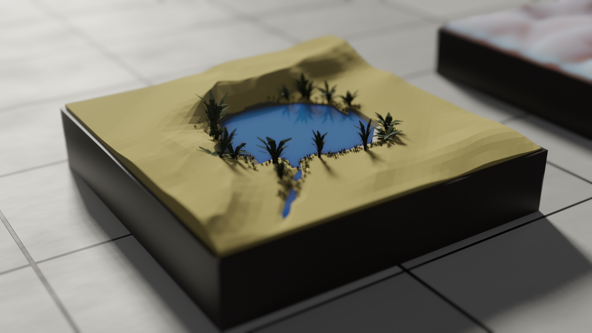 A low poly oasis set into a square of desert, sands built up into dunes on the far side. Around the shore, some greenery grows. A trail of water feeding the oasis emerges from the ground on the near side