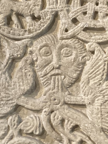 Green man 12th century carving in St Peter’s church Northampton staring bearded face with botanical elements coming from his mouth 