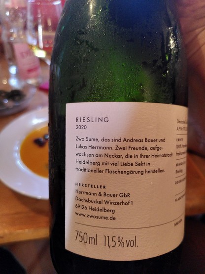 Etikett einer Sektflasche, Rückseite: 

"Riesling 2020

Zwo Sue, das sind Andreas Bauer und Lukas herrmann. Zwei Freunde, aufgewachsen am Neckar, die in ihrer Heimatstadt Heidelberg mit viel Liebe Sekt in traditioneller Flaschengärung herstellen.

Hersteller
Herrmann & Bauer GbR
Dachsbuckel Winzerhof 1
69126 Heidelberg
www.zwosume.de

750ml, 11,5%vol"