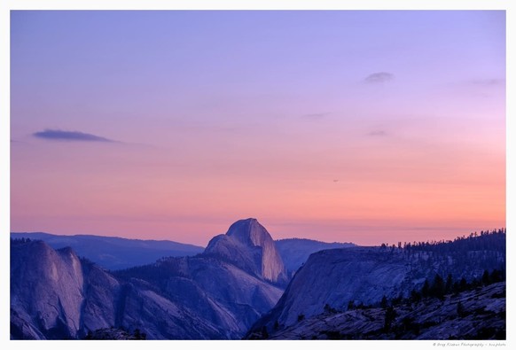 Half Dome seen from Olmstead Point at the blue hour, with bottom part of the photo occupied by the Sierra mountains and the Half Dome, and the top part showing the evening sky with violet and blue