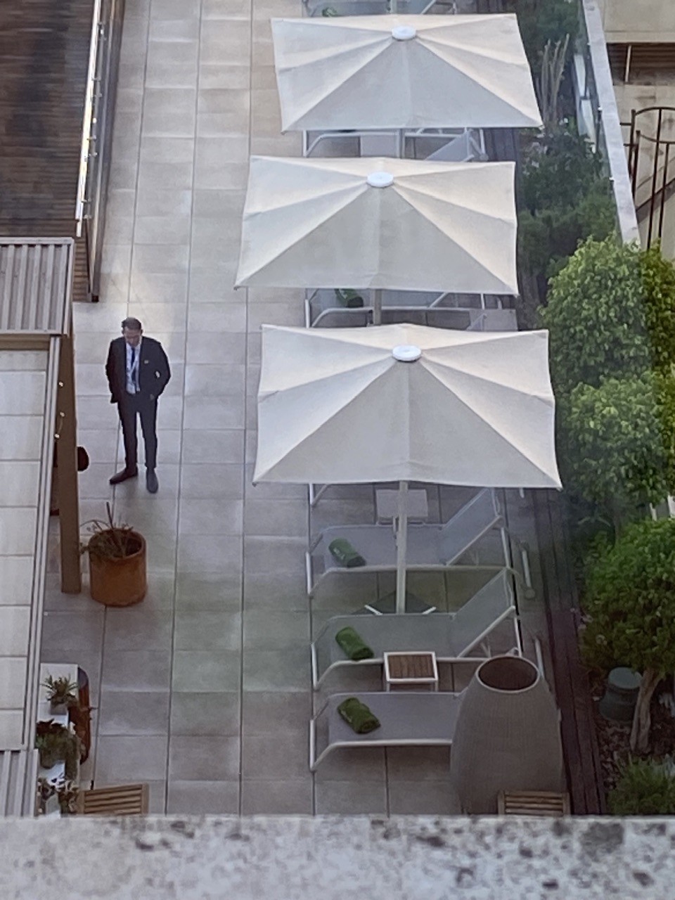 View from 7th floor of hotel overlooking the pool terrace. Mike stands resolutely, alone, alert, ready to do whatever needs to be done!