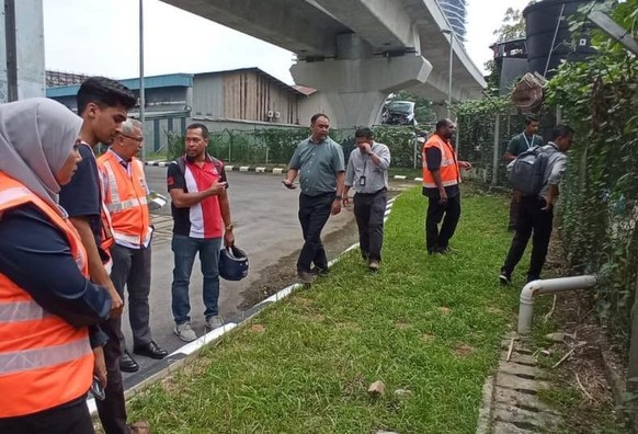 A group of people looking at the area where drainage pipe was illegally installed to dump water into the substation drainage.