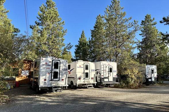 Vier Truck-Camper von Canadream zwischen den Bäumen im Campground.