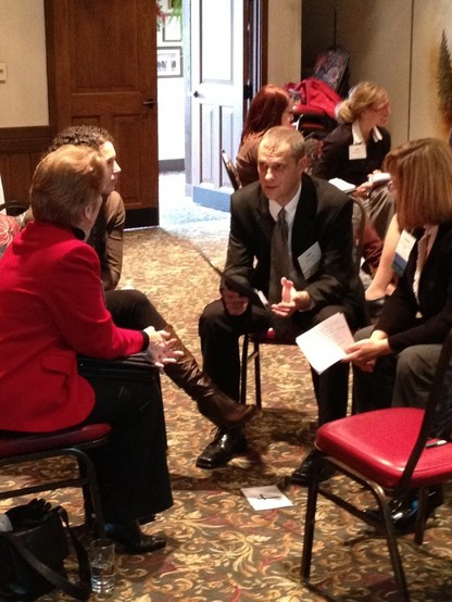 How do you facilitate change: photograph of a small group of people sitting in a circle of chairs