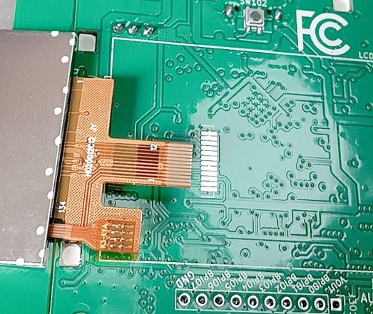 A photo of the back of a pcb and a lcd flex PCB. The FPCB is the wrong size.