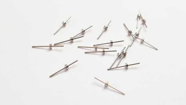A bunch of milled pins on a piece of paper. The pins are milled from copper and plated by nickel.