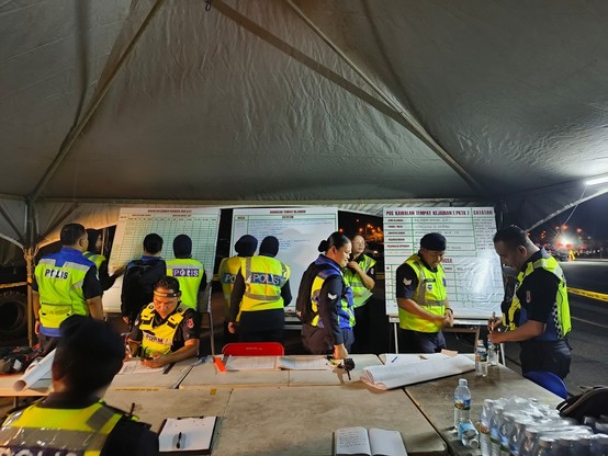 A group of people under incident control post tent.