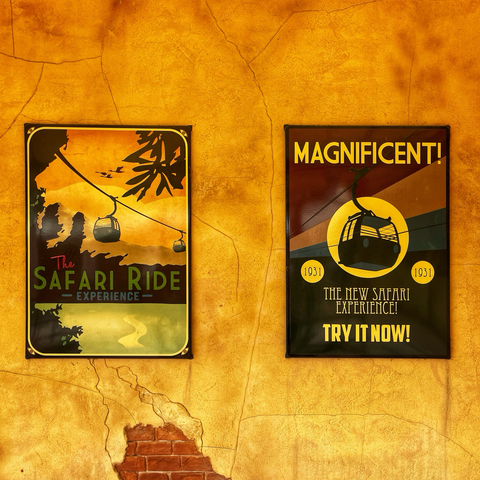 Photo of 2 stylised illustrated posters for Safaribanan. Text reads: “The Safari Ride Experience” and “Magnificent! 1931. The New Safari Experience! Try it now!”