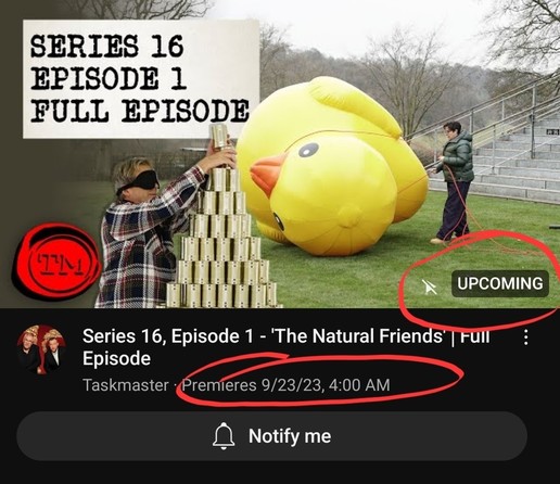 A cropped screenshot of the Taskmaster Youtube page, showing that the upcoming Series 16, Episode 1 of Taskmaster, titled "The Natural Friends", showing a blindfolded Julian Clary stacking tin cans on the left and Sue Perkins confronting a giant inflatable yellow rubber duck on the right. On the lower right side of the shot there is an "Upcoming" badge, indicating as well that the episode will be released on YouTube at 4 am Manila time on September 23.