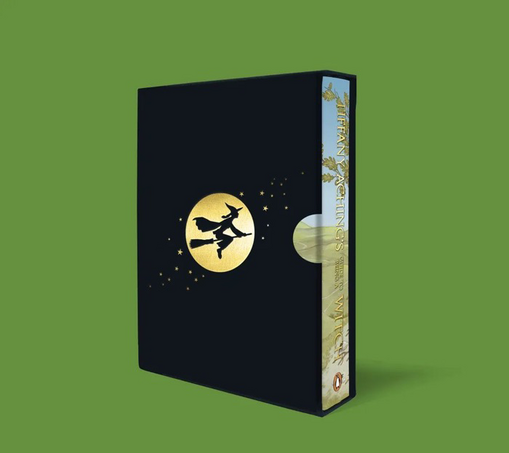 3D visual of book Tiffany Aching's Guide to Being a Witch inside a black slipcase with golden witch silhouette, against a green background.
