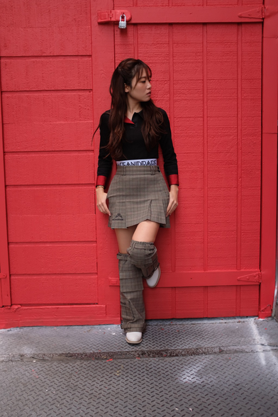 Girl standing by red wall
