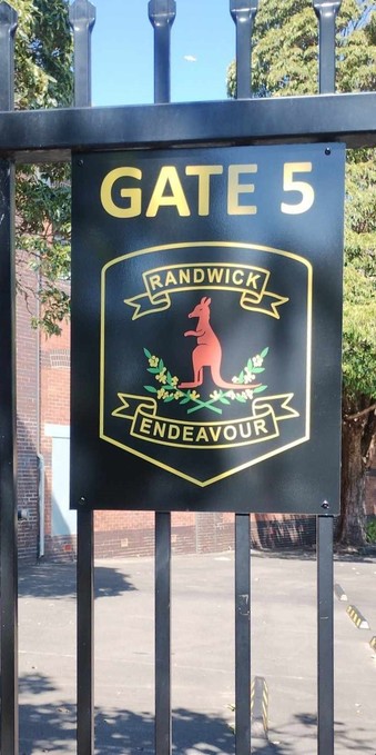 The logo for Randwick Public school: a kangaroo above two crossed wattle branches with the motto "RANDWICK ENDEAVOUR"