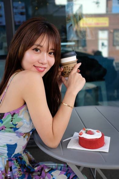 girl sitting outside cafe with coffee cup and cake