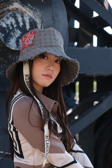 girl in hat by black machinery