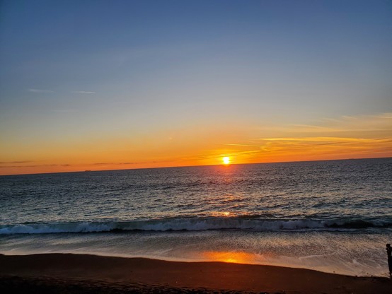 Old Sol preparing to do its disappearing act, with lovely orange glow over the deep blue of the ocean waves.