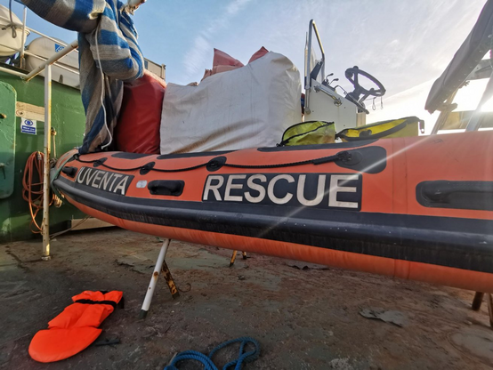 An Deck der IUVENTA, alles voller Rost und Staub. Einzelne Rettungswesten liegen rum, ein Teil des RHIBs ist zu sehen. Auf der Seite steht IUVENTA RESCUE.
