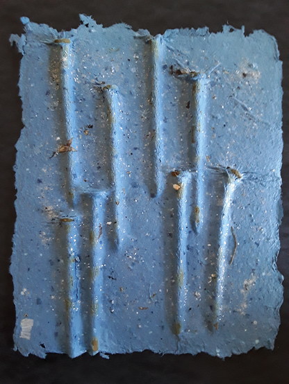 Blue cast paper relief sculpture of a group of nails.