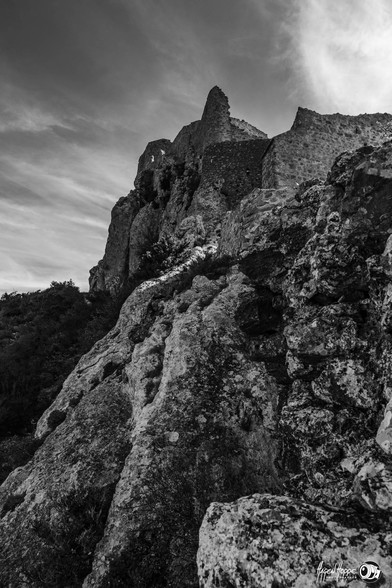 View to above to the castle in front of the sky, a stone in the foreground.