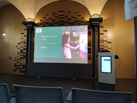 Picture of an empty stage with the Meet Qt slides on the screen