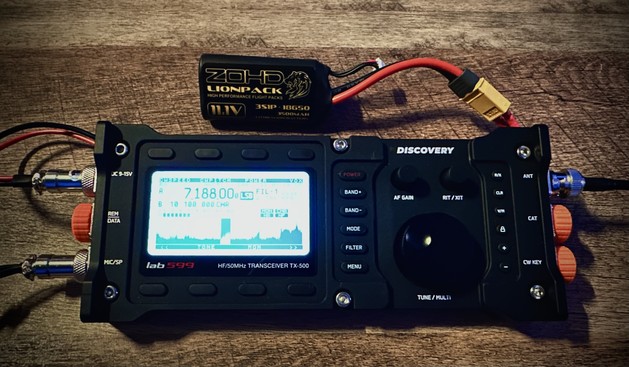 A sleek black amateur radio transceiver, with a small Lithium battery pack