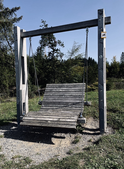 a large wooden swing as a resting point on the path