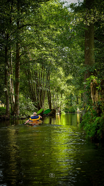 Two people paddling a kayak through the canals of the Spreewald, near Lübbenau, 2 Oct 2023. Nikon D5600, Nikkor DX 35 mm ƒ1.8G, ISO 320, ƒ3.5, 1/250s