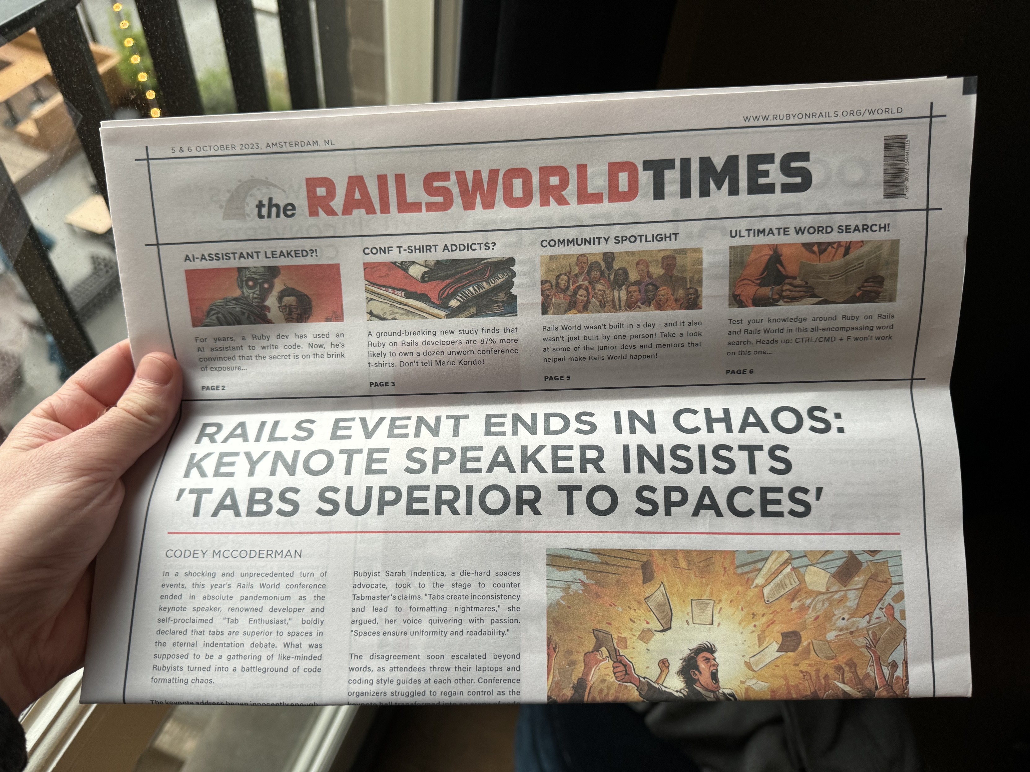 RailsWorld times newspaper with headline saying "Rails event ends in chaos: keynote speaker insists 'tabs superior to spaces'"