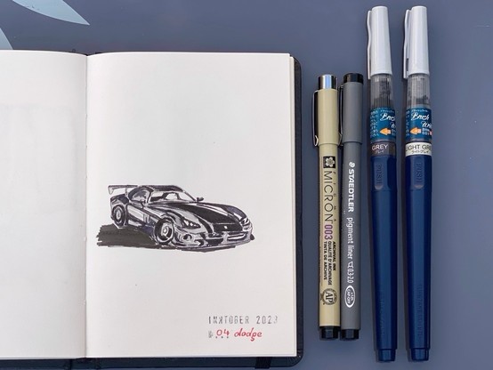 The drawing in my open artbook next to the pens I used: micron 003 black fineliner, Staedtler 0.3-2.0 black liner, light grey and grey ink brush pens