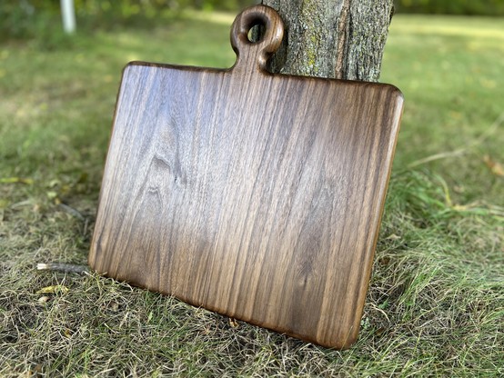 Large walnut cutting board. Rectangular with a small circular handle.