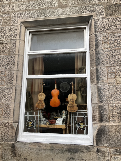 Window with display of vintage violins in Falkland, Scotland. 