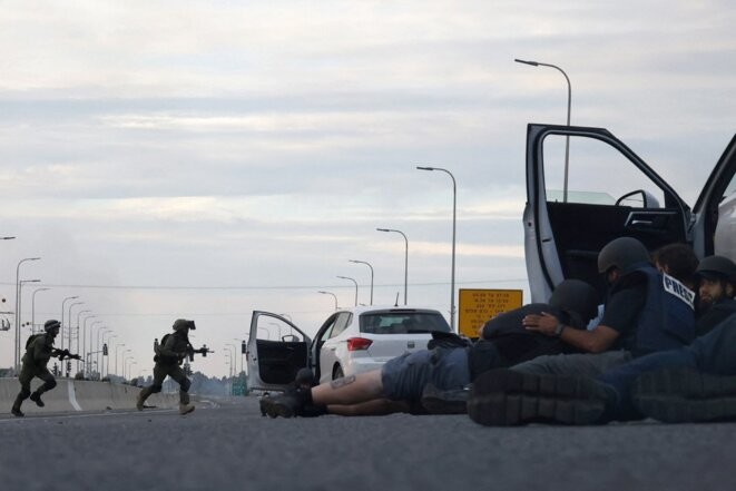 Des journalistes se mettent à couvert pendant des affrontements entre des soldats israéliens et des combattants du Hamas près du kibboutz Gevim, près de la frontière avec la bande de Gaza, le 7 octobre. © Photo Oren Ziv / AFP