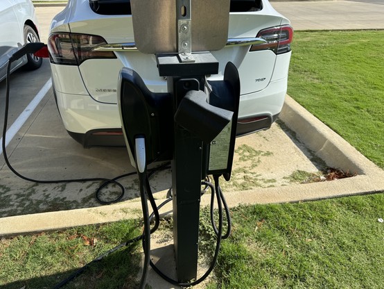 A picture of a parking space that has a Tesla Wall Connecter and a generic J1772 charger. My car was charging with the J1772 charger.