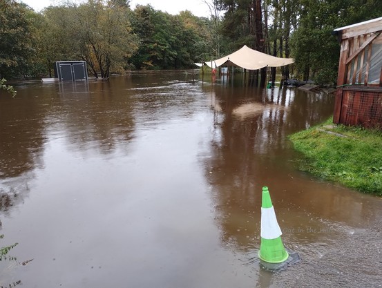 A flooded pub car park and beer garden. The river (at the back) now reaches all the way to me.