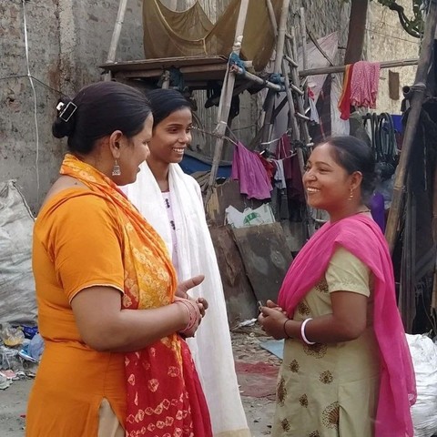 Community social workers speaking to a woman in slums of New Delhi