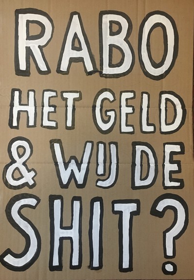 Protestbord met tekst “RABO HET GELD &WIJ DE SHIT?”
