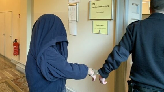 Ein Angeklagter wird für einen Missbrauchsprozess in einen Gerichtssaal geführt.