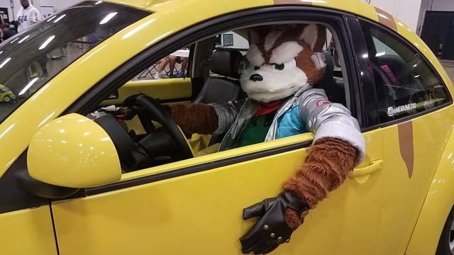 Fox McCloud in the driver's seat of a Pikachu-shaped Volkswagon Beetle.