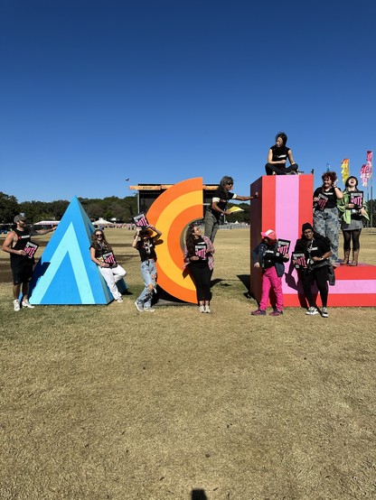 Headcount volunteers striking various poses all over giant A C L letters