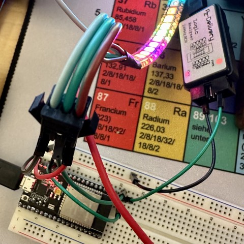 Photo of an ESP32 microcontroller that runs the WLED software and controls an RGB LED strip, with an attached logic analyzer.