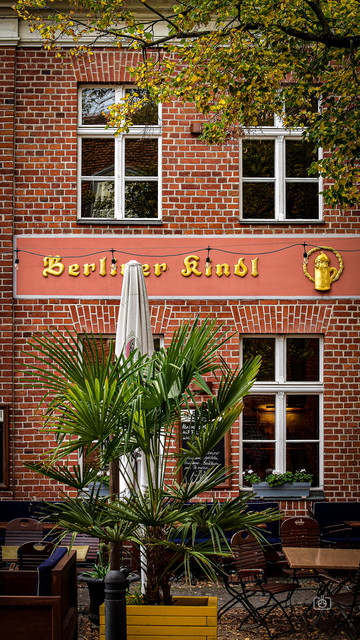 Windows on a red brick townhouse with the sign Berliner Kindl (a local beer), Dutch Quarter, Potsdam, 16 Oct 2023. Nikon D5600, Nikkor DX 35 mm ƒ1.8G, ISO 640, -0.3 ev, ƒ5.6, 1/250s