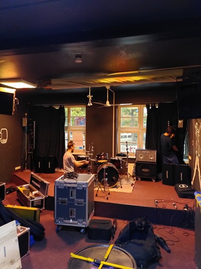 Stage at club Rote Zora with people setting up the instruments