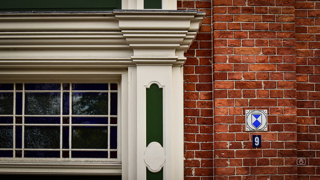 White and green carved portal and red brick wall, Dutch Quarter, Potsdam, 16 Oct 2023. Nikon D5600, Nikkor DX 35 mm ƒ1.8G, ISO 640, -0.7 ev, ƒ9, 1/250s