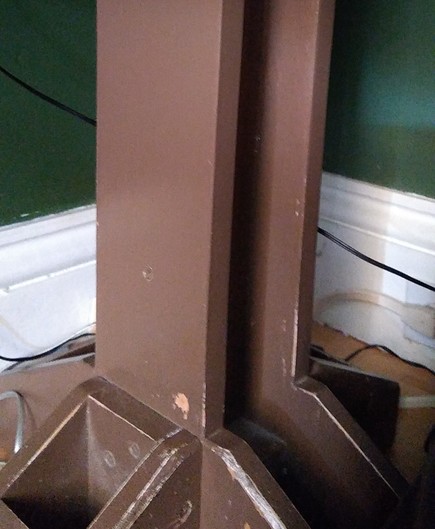 A vertical brown-painted post of a leg supports my work desk. It's a bit beaten up, but not bad for 22yrs old.