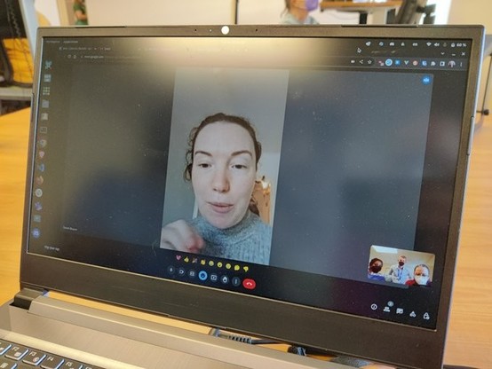 laptop with a virtual meeting on and four people on the screen