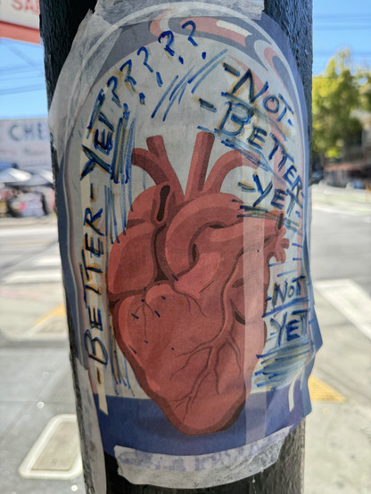 A thin paper (like newspaper) taped to a post on Valencia street with masking tape. It has a painting of a heart (that may be printed on, or it could be done byt the graffiti artist) and the graff artist has written "Better yet????? Not better yet. Not Yet." in blue ink. 
The vibe is a little like a collage a kid would make. 