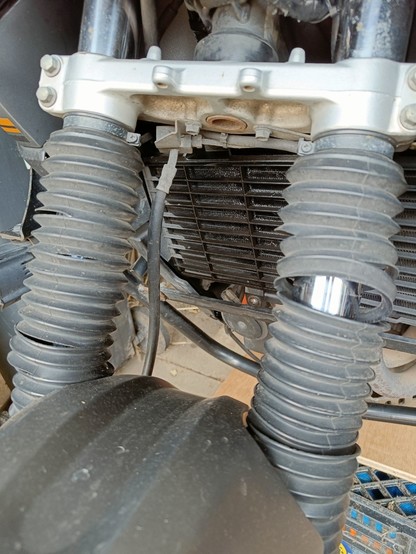 Dirty and ripped fork boots on the motorcycle